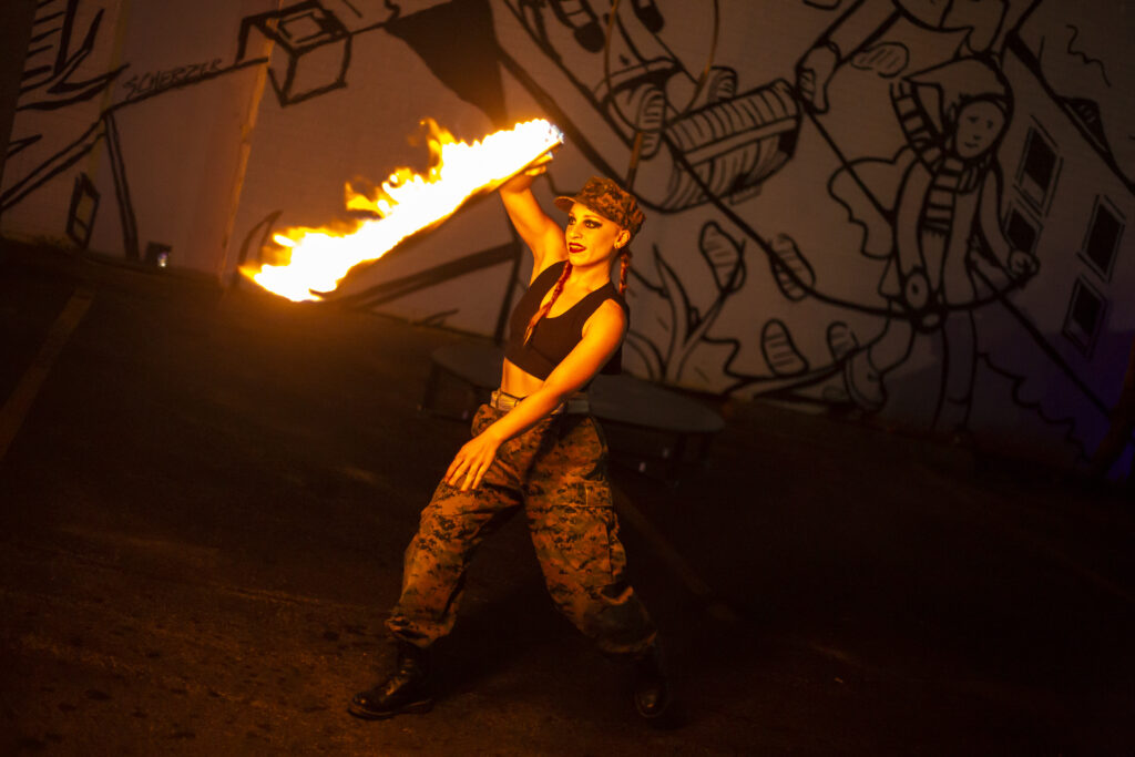 A glowing figure holding a torch in a dark, artistic setting.