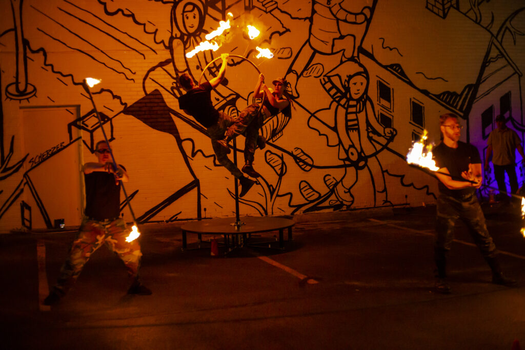 A lit sparkler on a dark surface with glowing sparks.