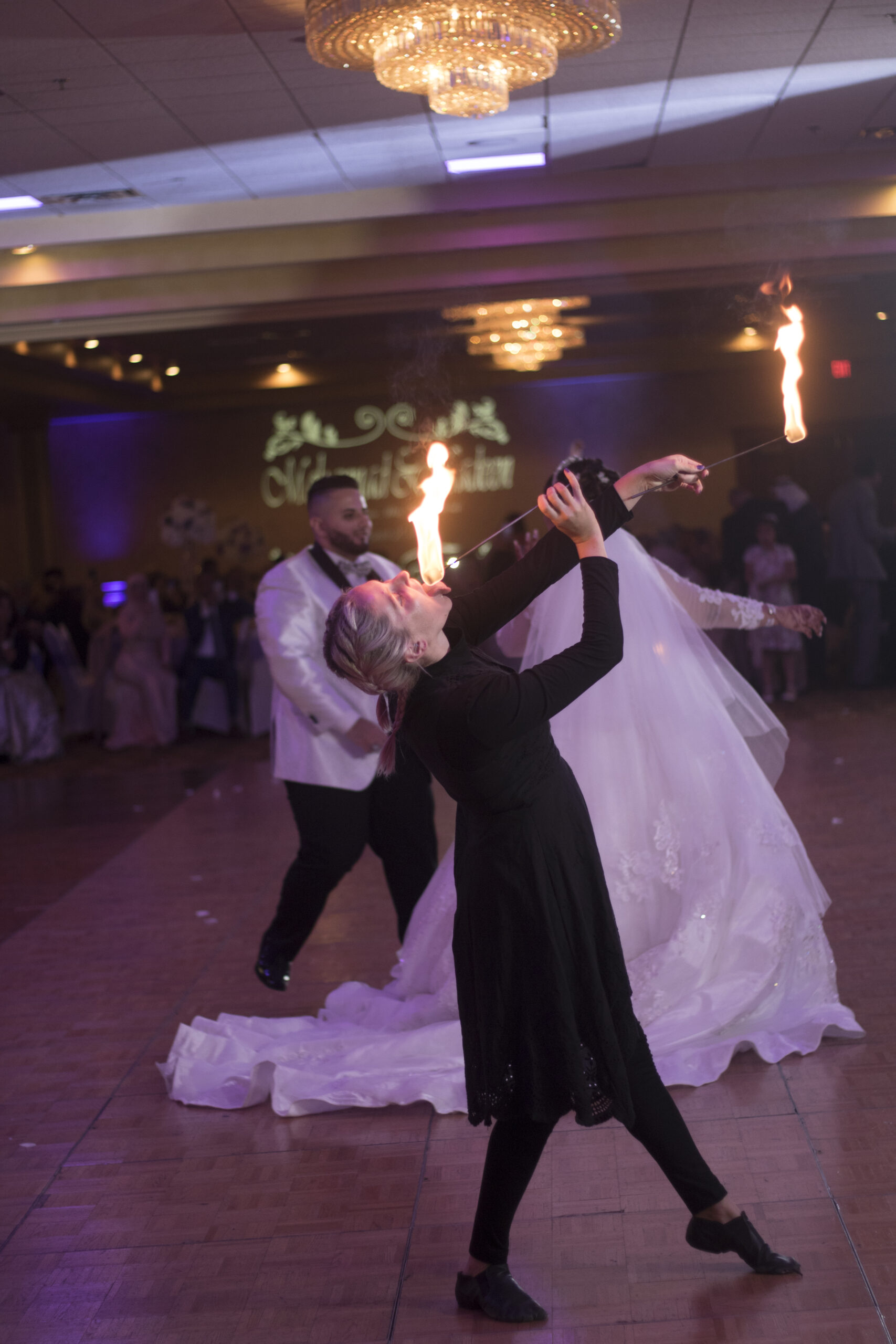 A bride and groom dancing amidst sparklers at their wedding reception.