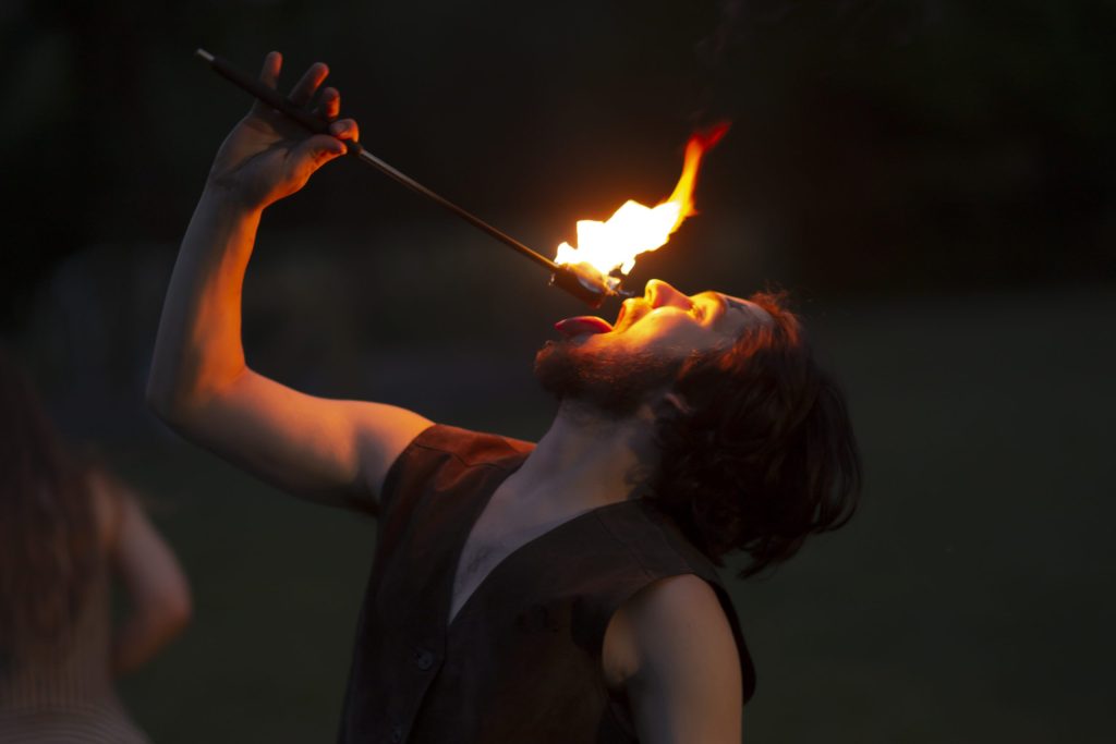 Person fire-eating torch at dusk