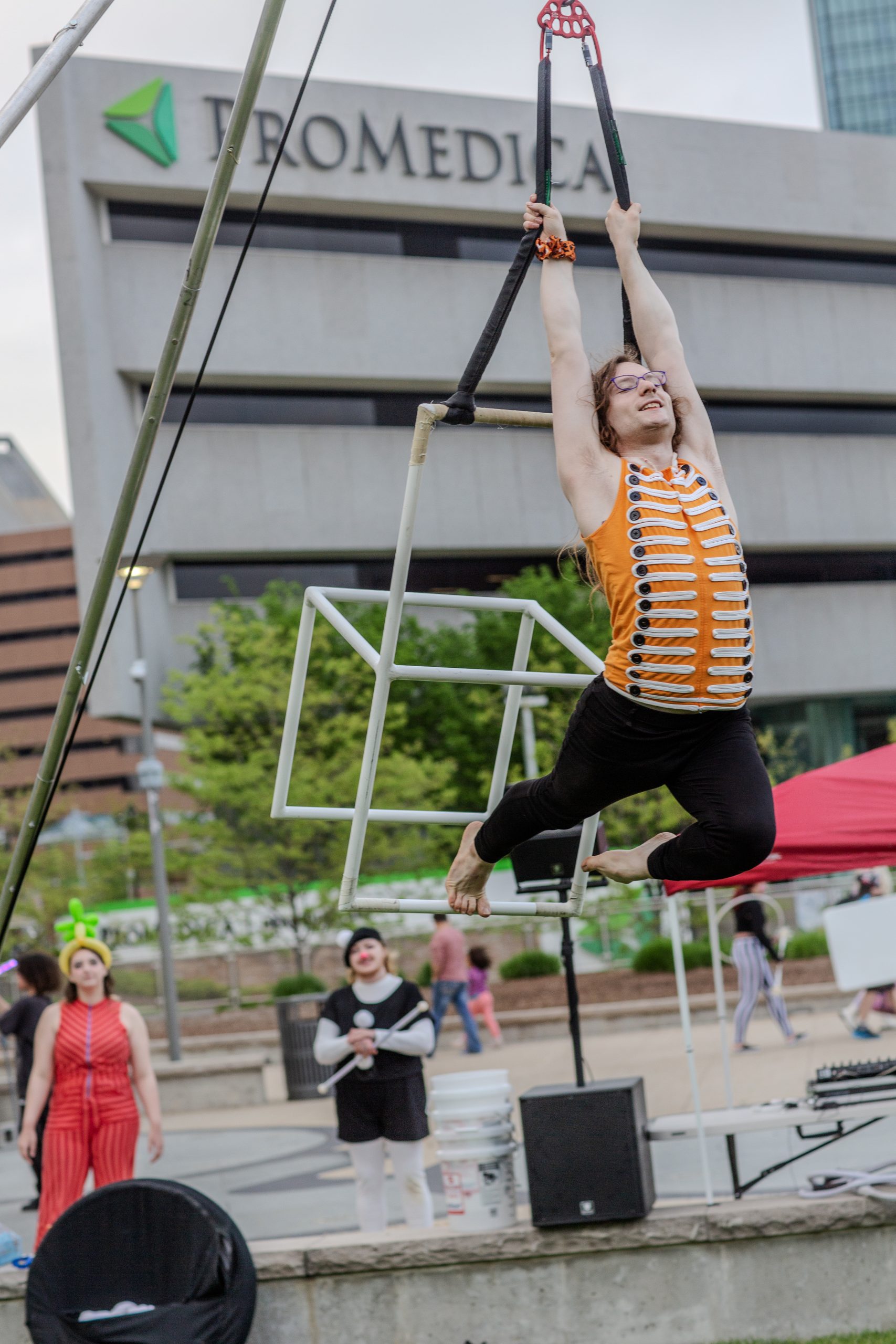 A child swinging on a trapeze outdoors with a smile.