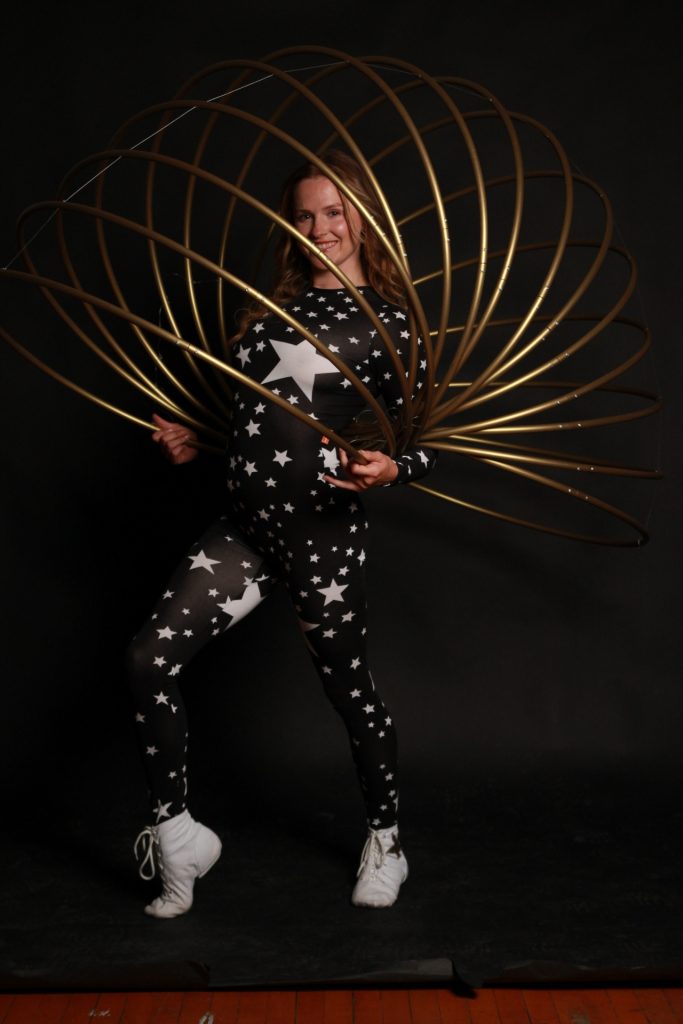 Person in a star-patterned outfit with a large golden hoop accessory.