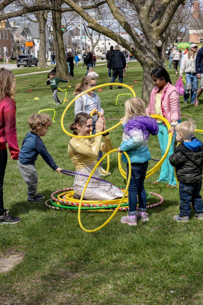 Children playing with colorful hula hoops in a park.