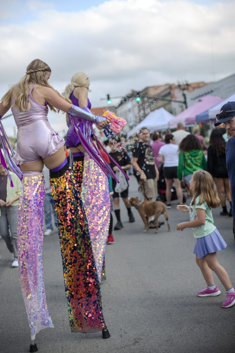 Performers on stilts at outdoor festival.