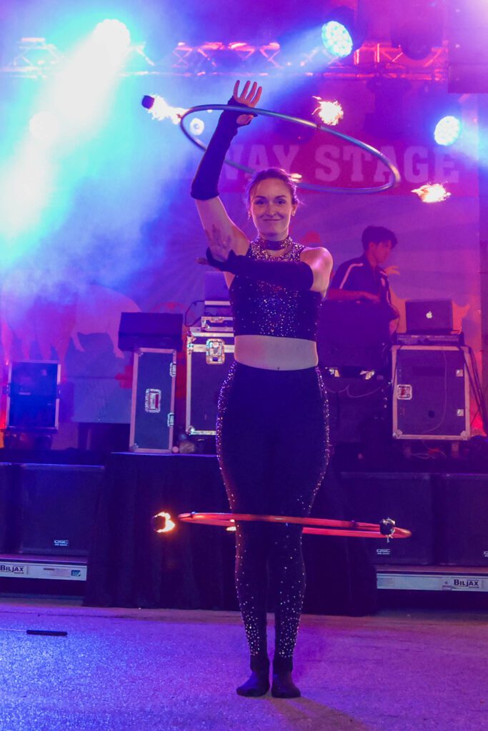 Performer hula hooping with fire on stage.