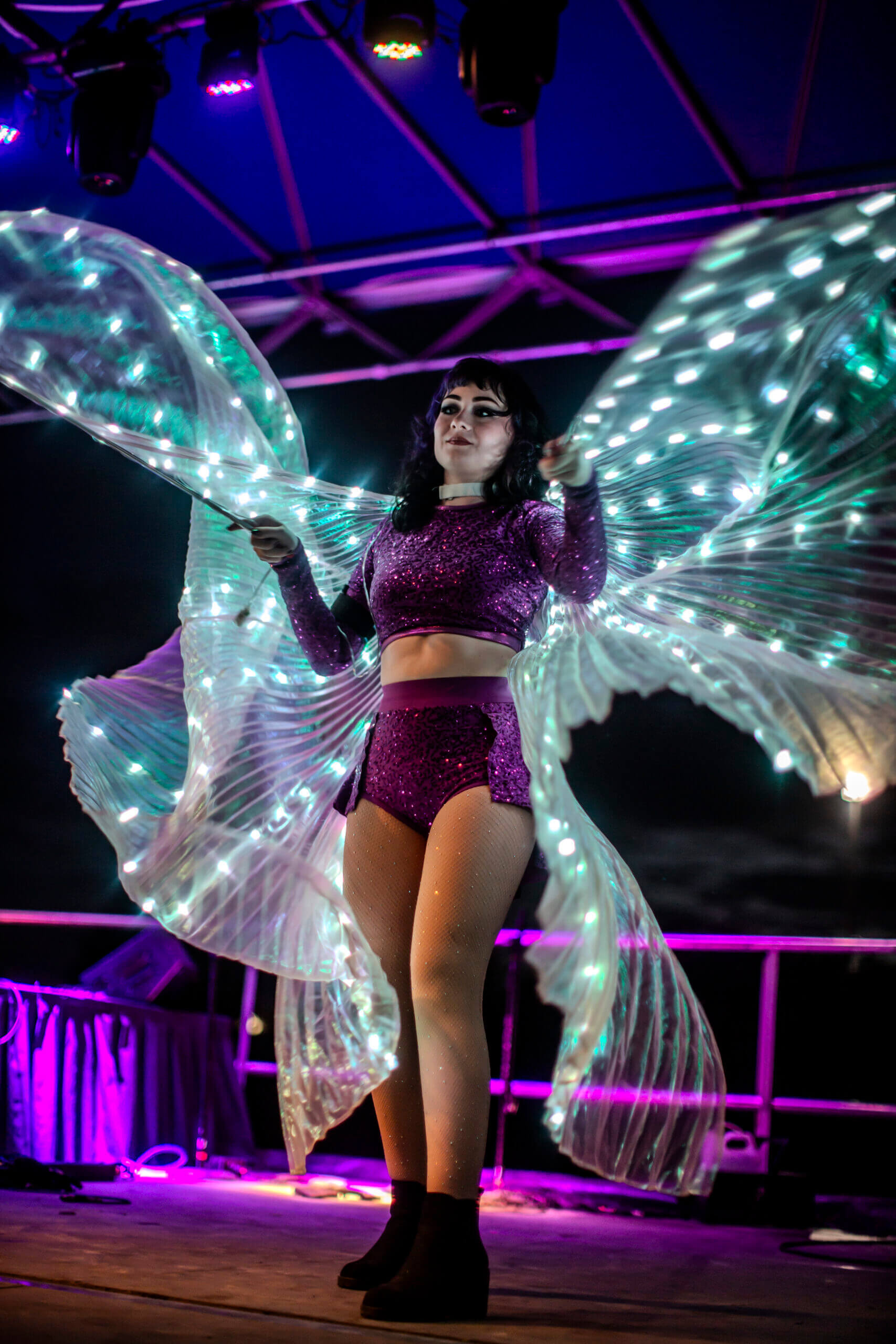 Dancer with LED-lit wings in purple
