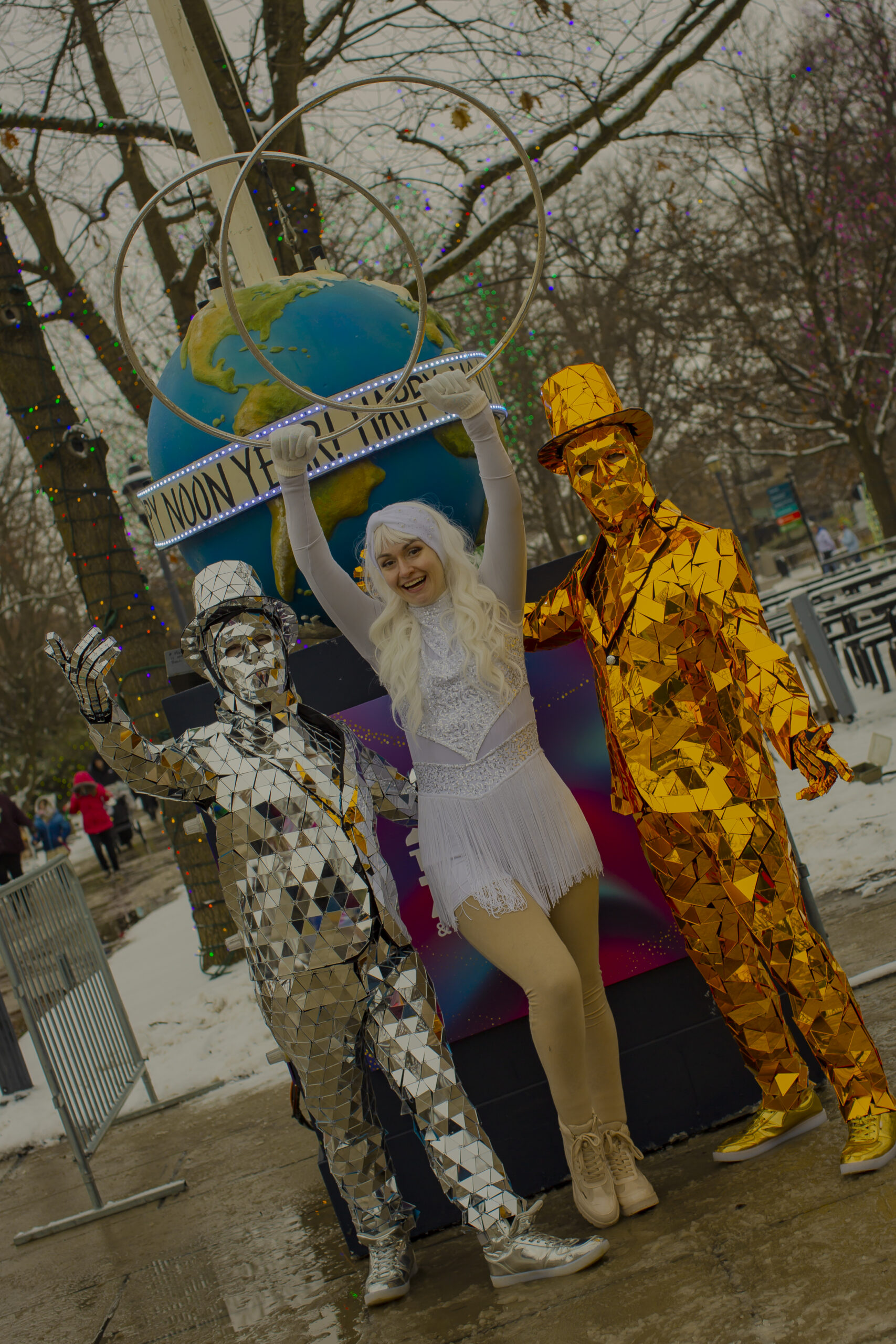 Three street performers in mirrored and white costumes
