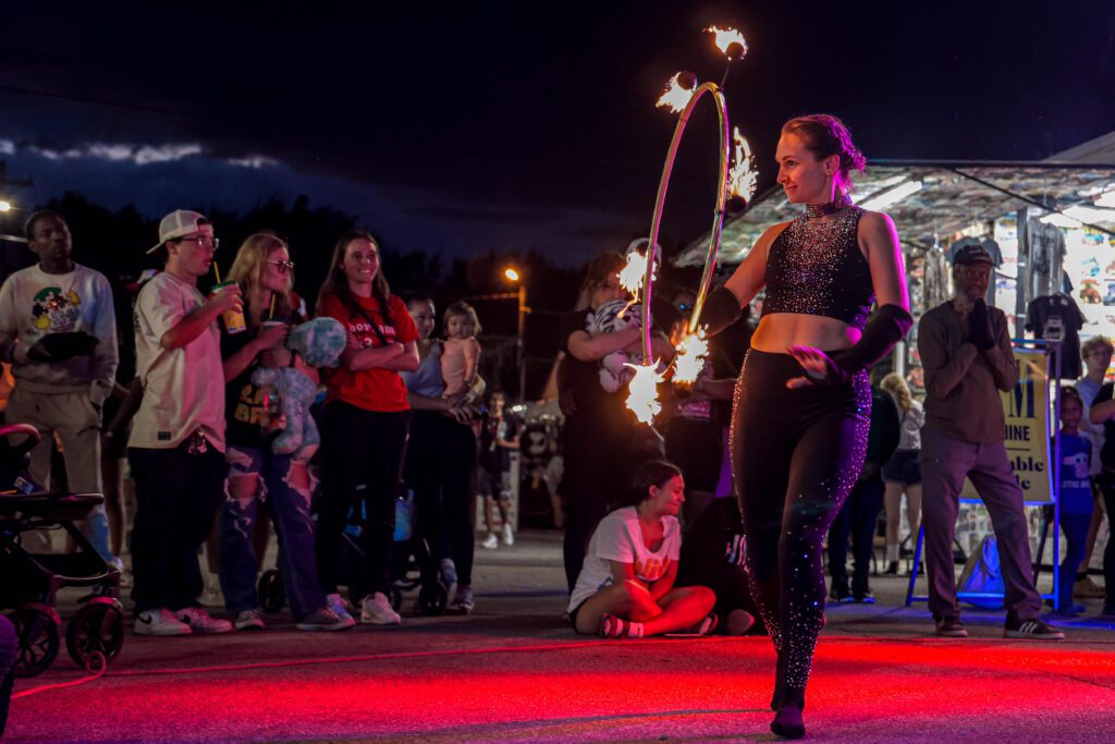 Night fire-hoop performer entertaining outdoor crowd