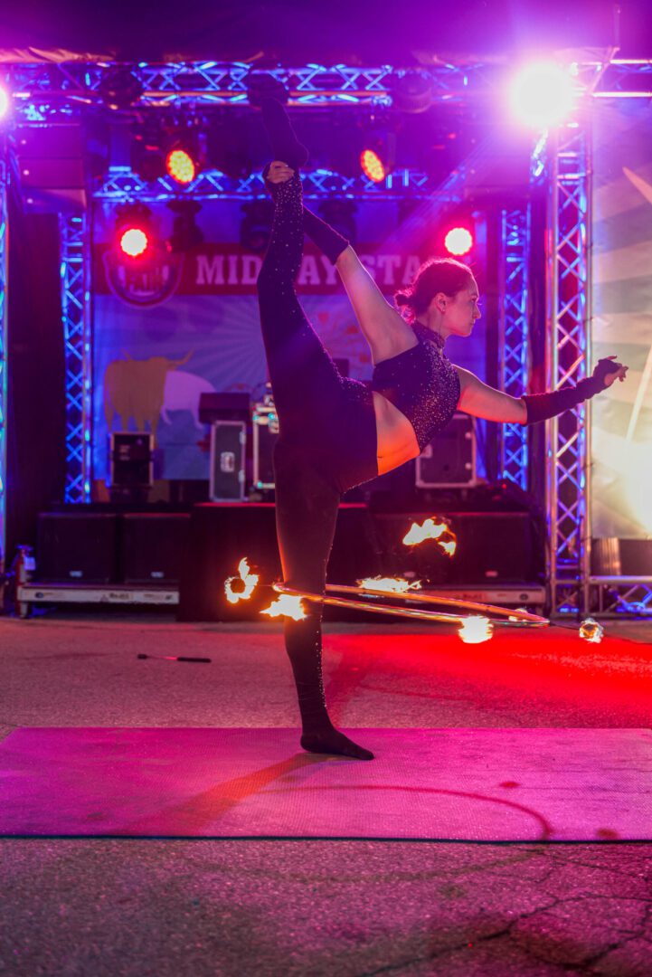 Contortionist balancing with flaming hula hoop