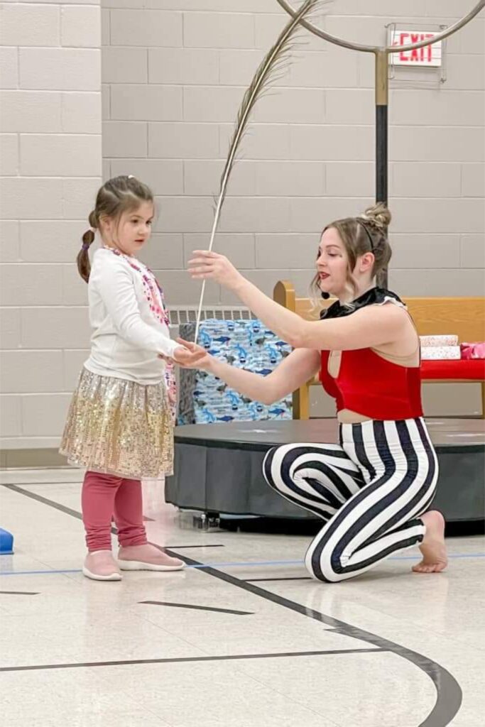 Performer creating giant bubble around young girl