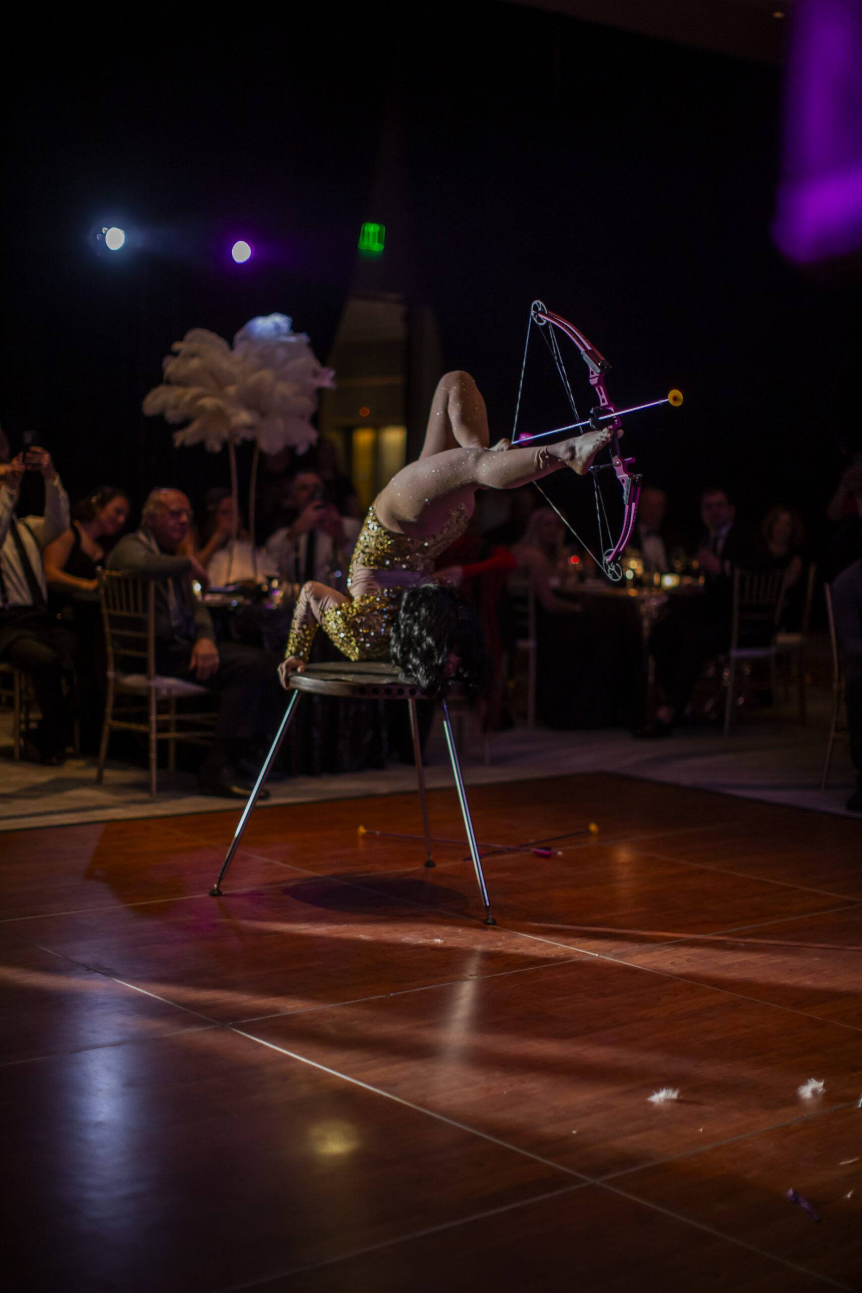 Acrobatic archer in backbend on chair