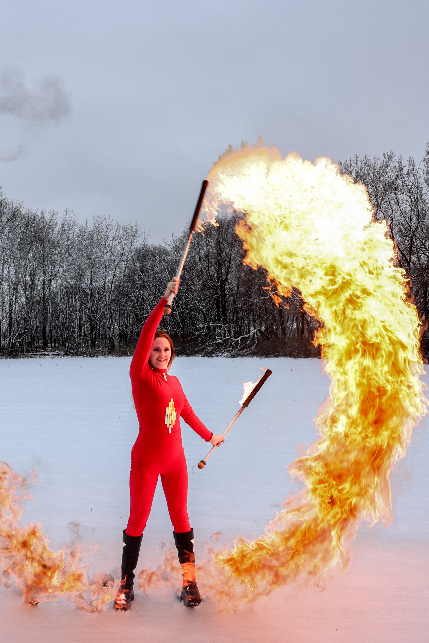 Fire performer in red suit with flaming torches