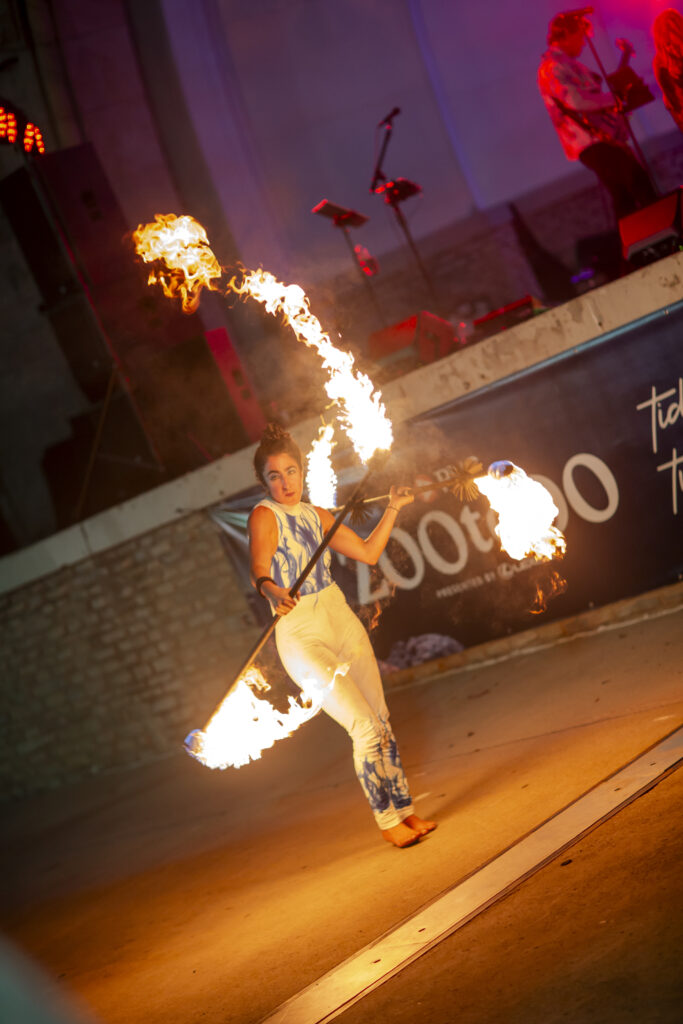 Fire dancer spinning flaming staff at night