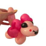 "Hand holding a pink balloon dog."